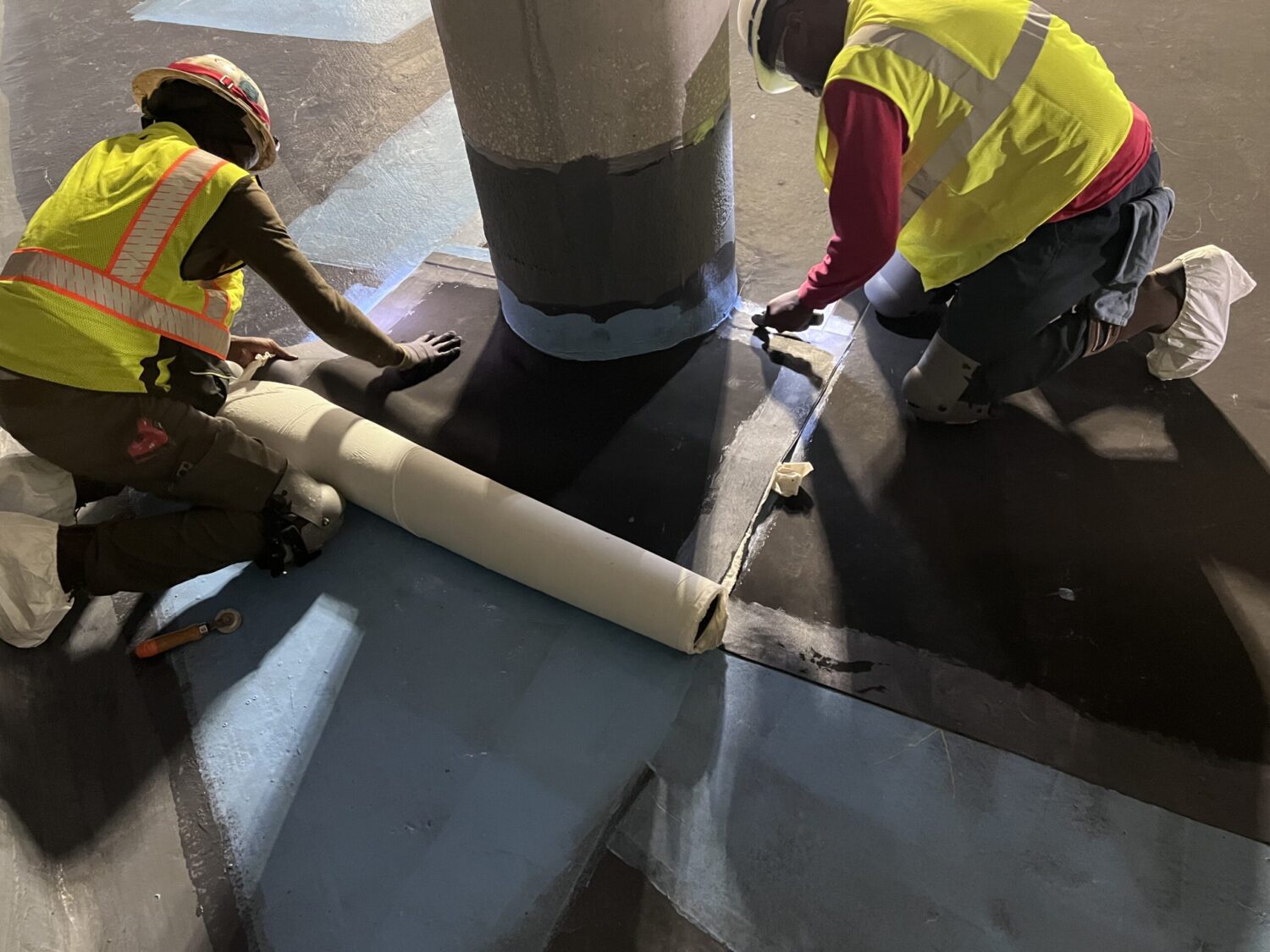 two men installing rubber lining